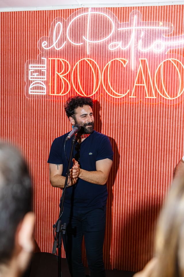 Singer in front of the “El Patio del Bocao” neon