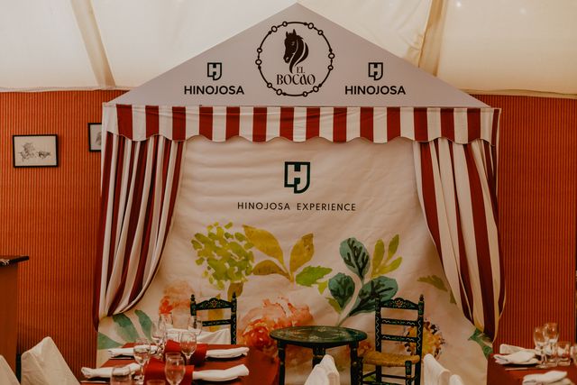 Photocall del evento de Hinojosa con el escudo de El Bocao y mesas servidas
