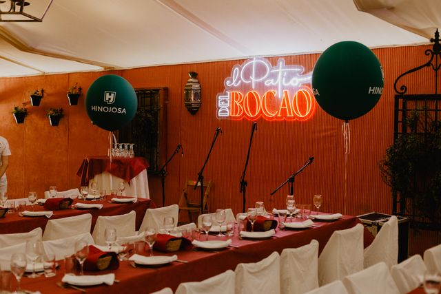 Sala del evento con el neón, globos de Hinojosa y la mesa montada