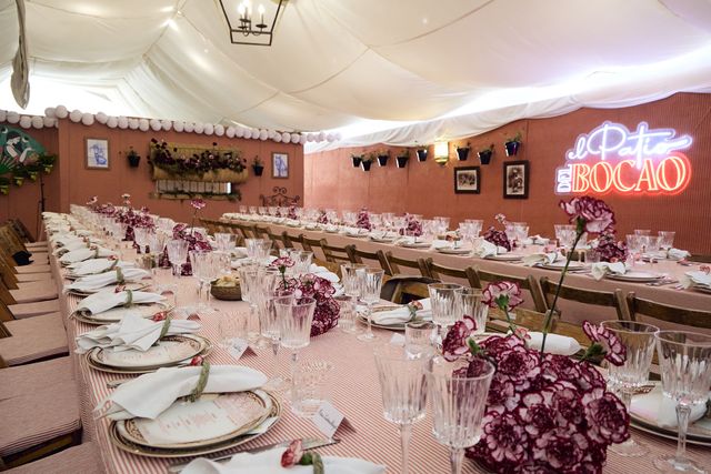 Long table laid beneath the “El Patio del Bocao” neon before a lunch