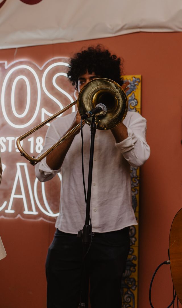 Trombonista ante un neón de Larios y El Bocao